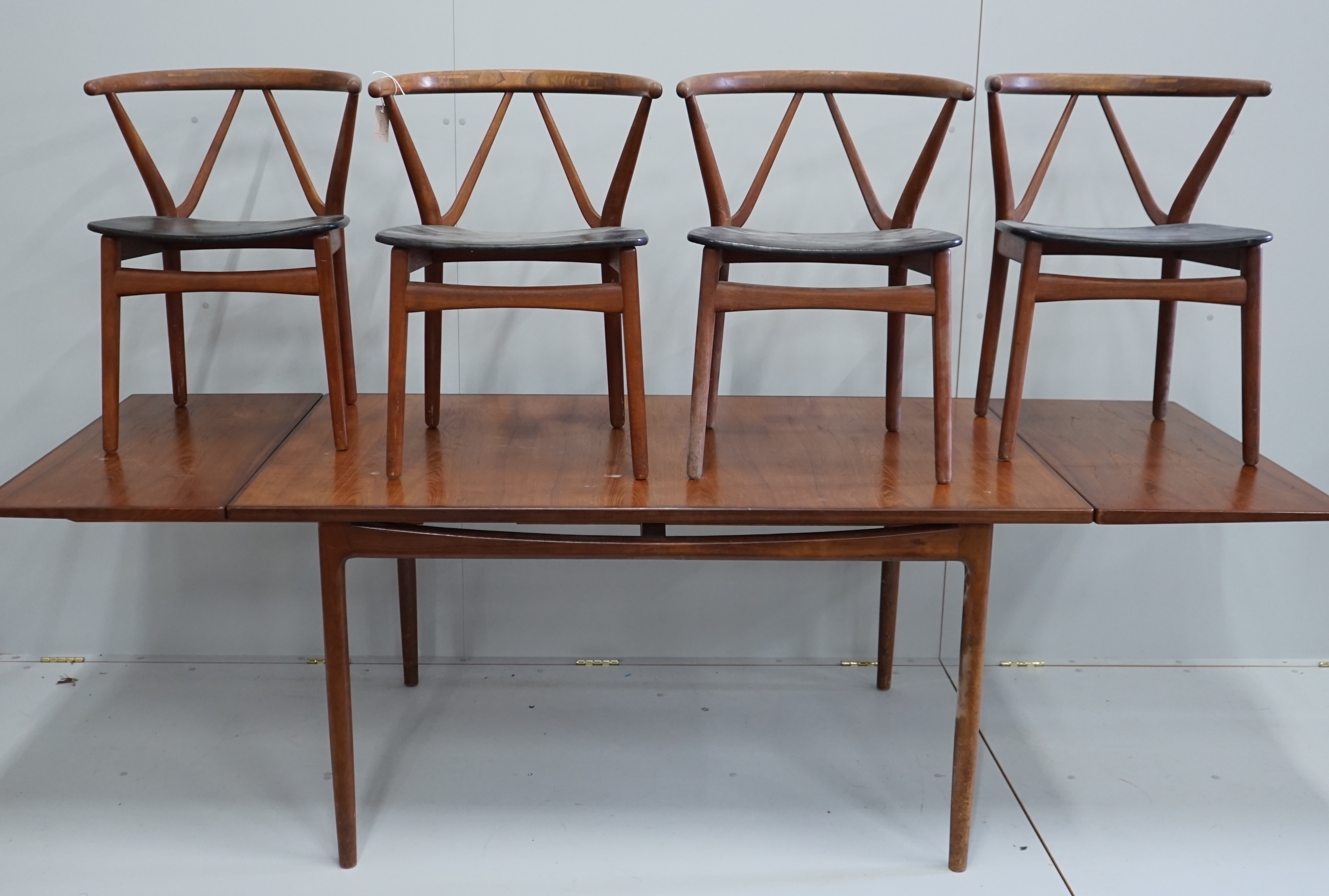 Henning Kjaernulf for Bruno Hansen, four Model 225 'Wishbone' teak dining chairs, width 55cm, depth 44cm, height 64cm and a rectangular extending teak dining table, 244cm extended, width 89cm, height 72cm